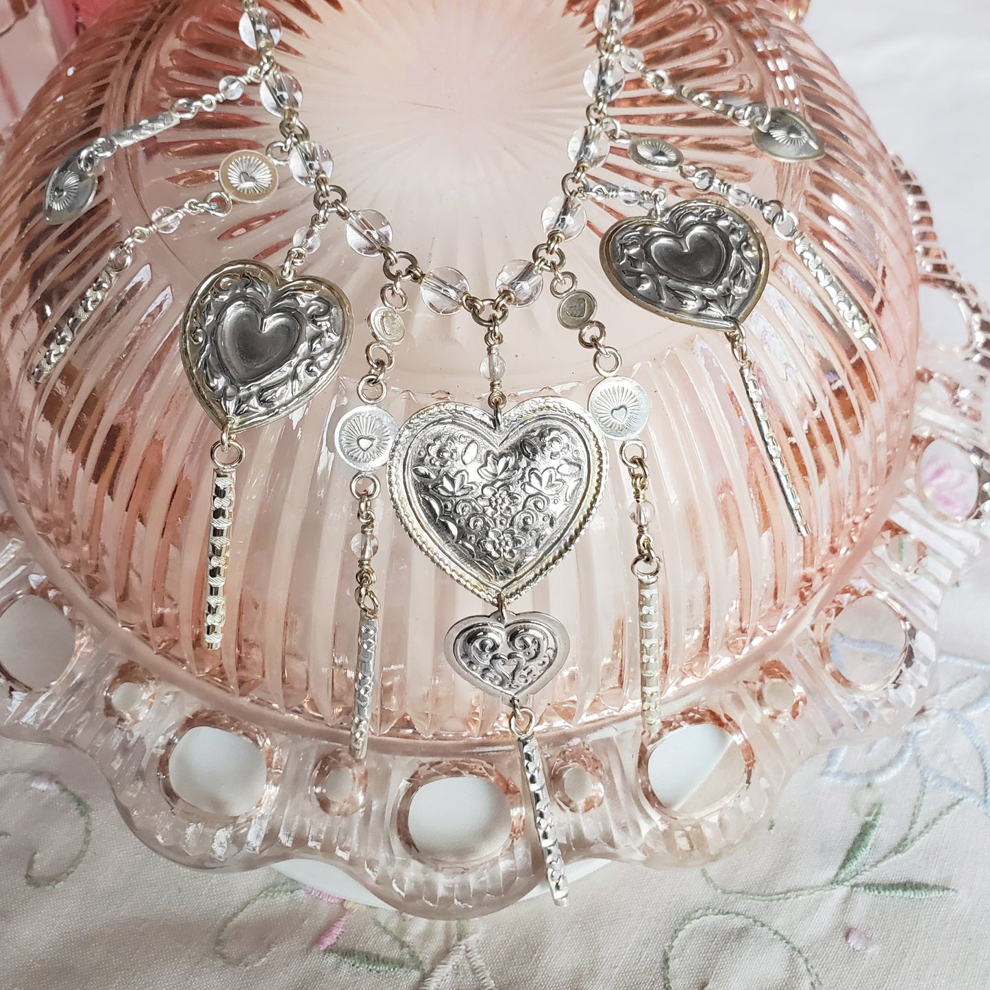 All components are hand stamped using dies and stamps from around the world. Some are vintage. The focal heart bares a lotus motif from India and the radiant heart disc features a handmade stamp from the Navajo nation.